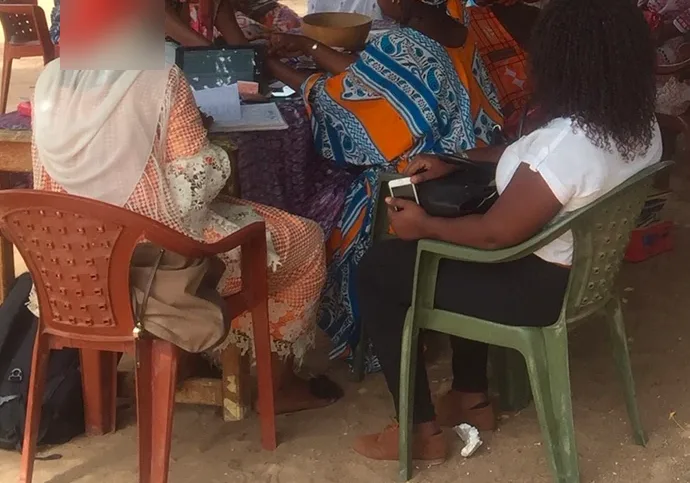 Séance de formation en plein air : des seniors apprennent à utiliser une tablette autour d'une table